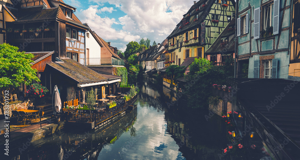 Tranquil canals with reflections in the pretty town of Colmar, Alsace, France. Stunning colorful ornamented facades in medieval Little Venice district - obrazy, fototapety, plakaty 