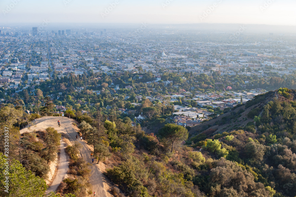 Overlooking walking  trail on Griffith park ,city of Los Angeles in the background on a hazy sunny day