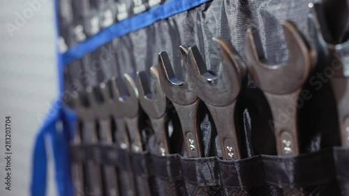Close up of many wrenches of different sizes hang in store automotive repair work job tools adjustable wrench automotive mechanic basics boat repair broken slow motion photo