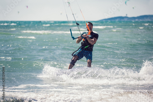 Kitesurfing. Man rides on kite on waves © Mediteraneo