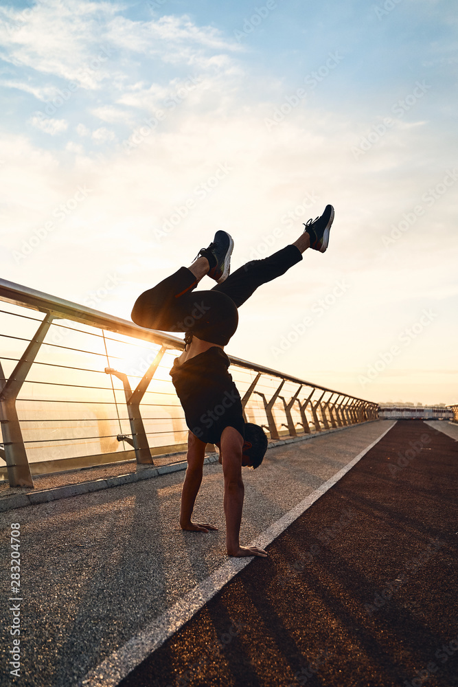 Fototapeta premium Young man doing exercise early in the morning on a pathway