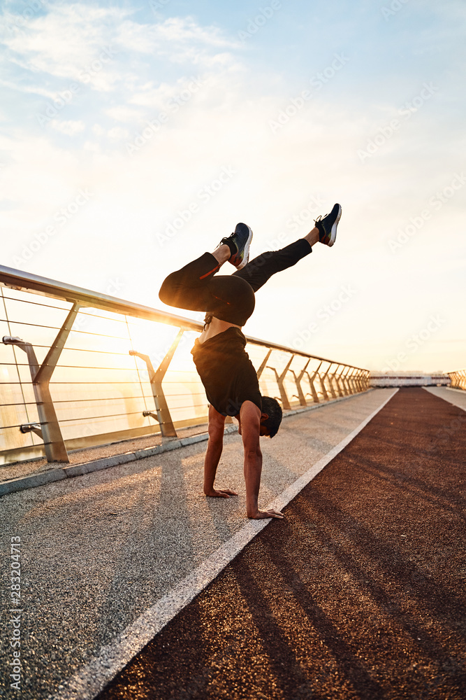 Young man doing exercise early in the morning on a pathway Young man doing exercise early in the morning on a pathway