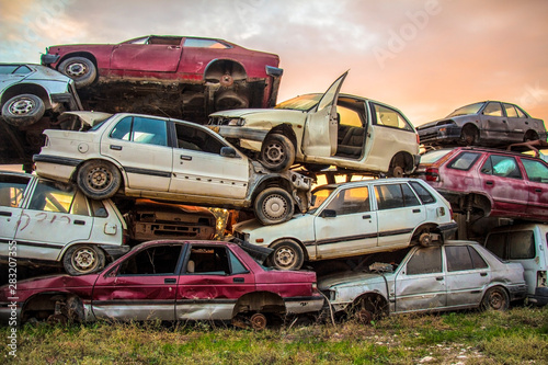 dump of old cars on green grass at sunny day 