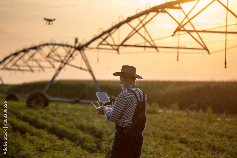 Farmer with drone in field with irrigation system Farmer with drone in field with irrigation system