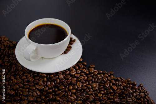 cup of coffee with beans on black background