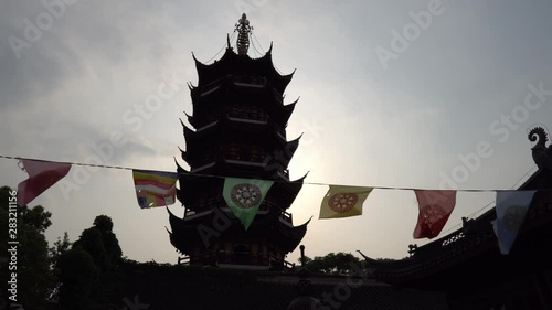  Nanjing Gujiming Buddhist Temple Pagoda with Waving Colorful Prayer Flags Depicting the Dharmachakra Wheel of Dharma at Late Afternoon photo