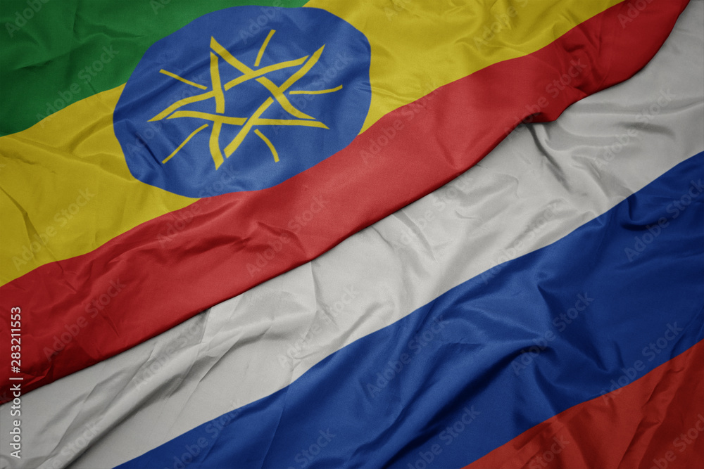 waving colorful flag of russia and national flag of ethiopia.