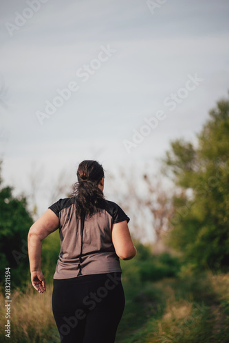 Cropped portrait of overweight runner go jogging outdoors. Weight loss, sports, healthy lifestyle