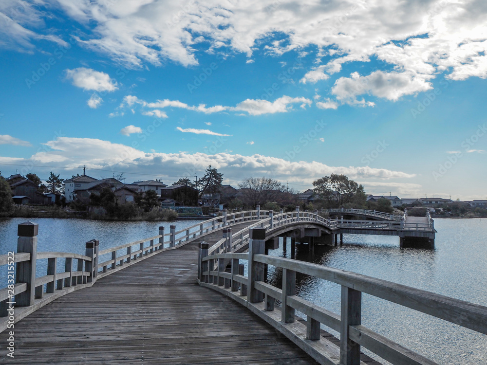Beautiful scene of wooden bridge over the small lake on blue sky with clouds background, copy space,Japan