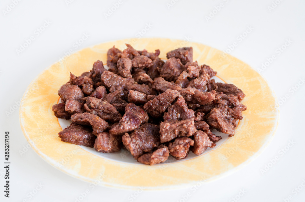Close-up shoot of tasty meat on small plate with white background Close-up shoot of tasty meat on small plate with white background
