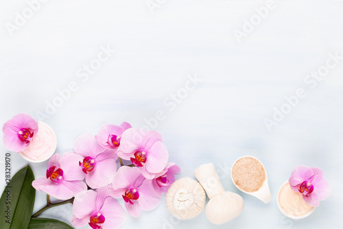 Sea salt, aromatherapy oil in bottles and orchid on vintage wooden background.