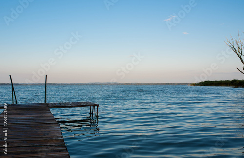 Wood deck over blue Balaton lake in Hungary at a cold morning at summertime  copy space.