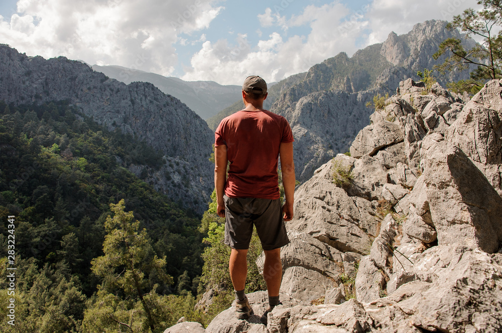 Rear view man standing on the rock on the beautiful landscape