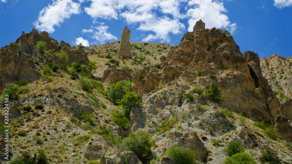 Curving roads in a green nature with pointed and steep rocks