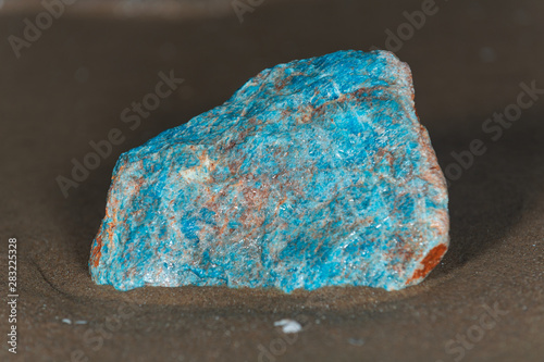 Fotografía High grade rough natural Blue Apatite Specimen from Madagascar on wet sand  in front of the lake at sunrise
