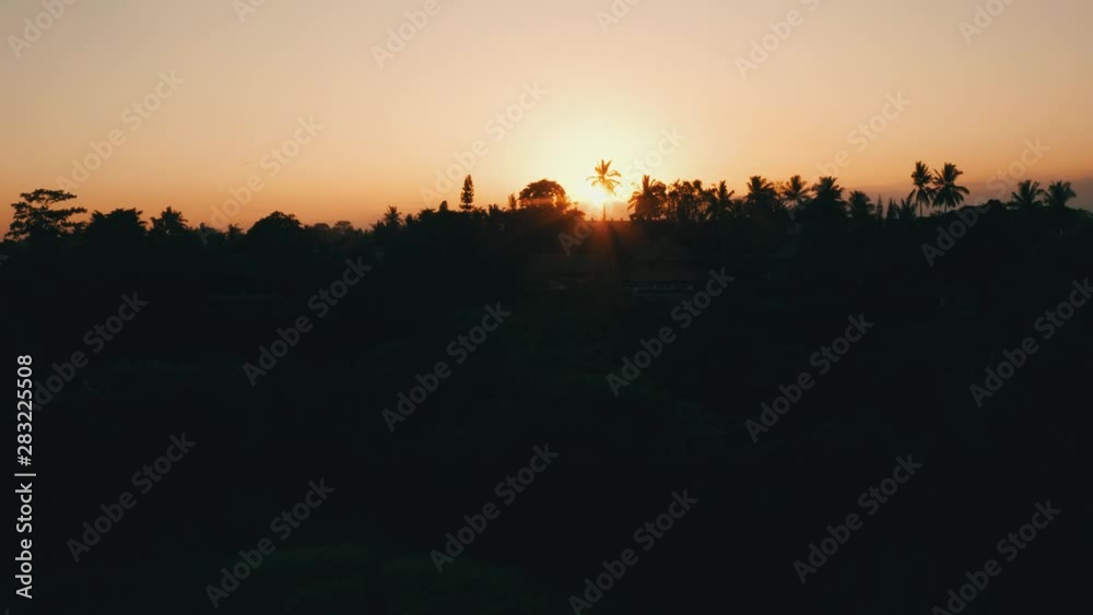 Aerial drone view of golden sunset sky above tropical island with resorts and hotels Aerial drone view of golden sunset sky above tropical island with resorts and hotels