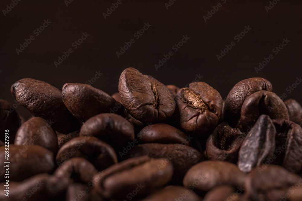 Naklejka premium Ziarna kawy na kamiennym tle. Widok z góry z miejscem na kopię tekstu. Tło palonych ziaren kawy. Tekstury fasoli, makro