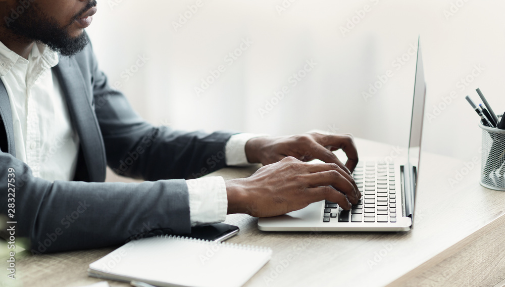 © Prostock-studio - Unrecognizable businessman working on laptop in modern office © Prostock-studio - Unrecognizable businessman working on laptop in modern office