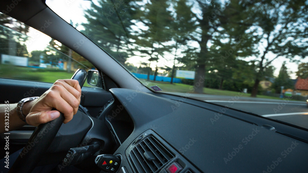 Hands of a driver on a wheel of a car (motion blurred image) Hands of a driver on a wheel of a car (motion blurred image)