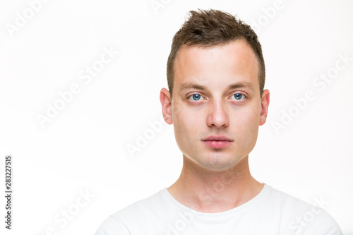Portrait of a handsome young man, perfectly calm, facing the camera with emotionless expression photo
