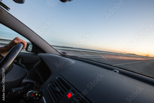 Hands of a driver on a wheel of a car (motion blurred image)