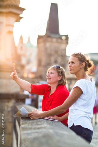 Photography Mother and daughter traveling - two female tourists studying a map, discovering