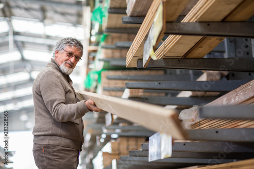 Man choosing and buying construction wood in a DIY store for his DIY home re-modeling project