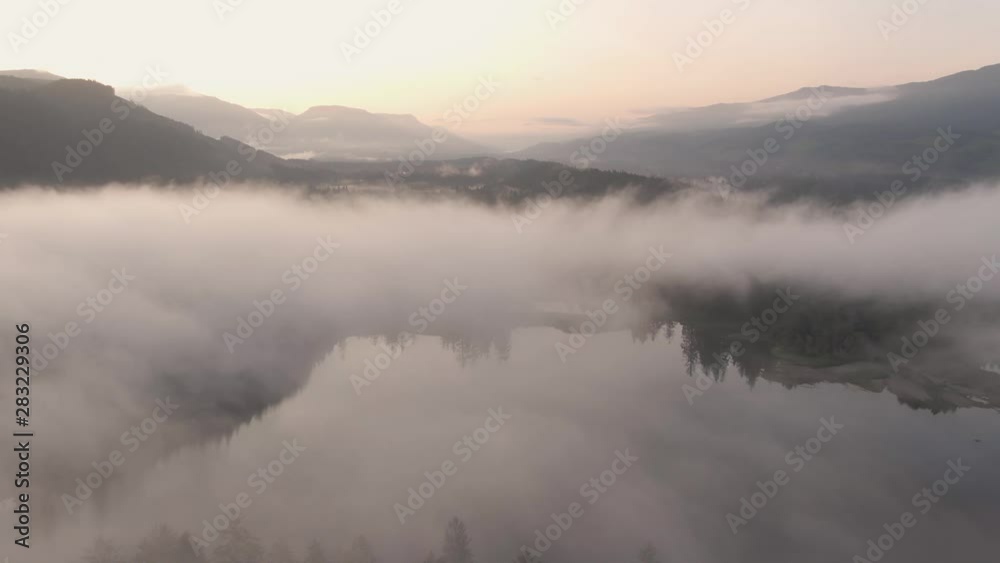 Aerial View of Fairy Lake covered in clouds during a vibrant summer sunrise. Taken near Port Renfrew, Vancouver Island, British Columbia, Canada. Aerial View of Fairy Lake covered in clouds during a vibrant summer sunrise. Taken near Port Renfrew, Vancouver Island, British Columbia, Canada.
