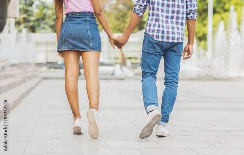 Teen romance. Couple holding hands enjoying date in the city.