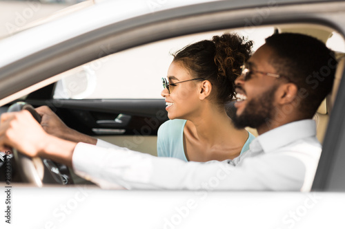 Young black couple in car on road trip, travelling together