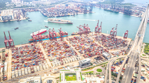 Hong Kong port industrial district with cargo container ship, cranes, car traffic on road and Stonecutters bridge. Logistic industry or freight transportation business concept photo