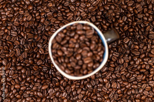 coffee beans background with a coffee mug full of coffee beans.