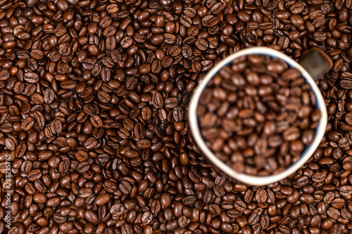 coffee beans background with a coffee mug full of coffee beans.