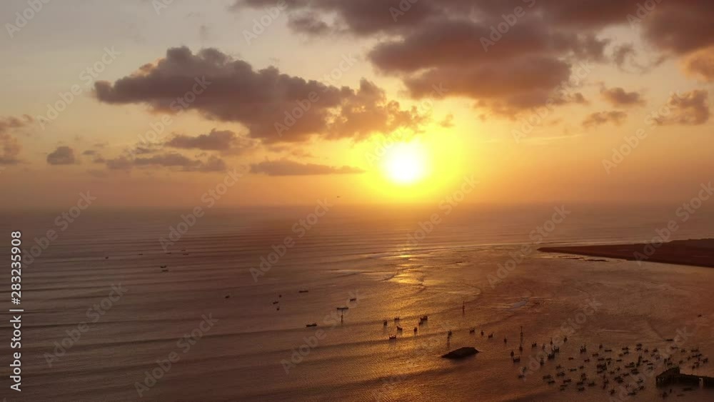 Aerial video shooting at sunset. The sun sets behind the clouds on the background of the Indian Ocean. Aerial video shooting at sunset. The sun sets behind the clouds on the background of the Indian Ocean.
