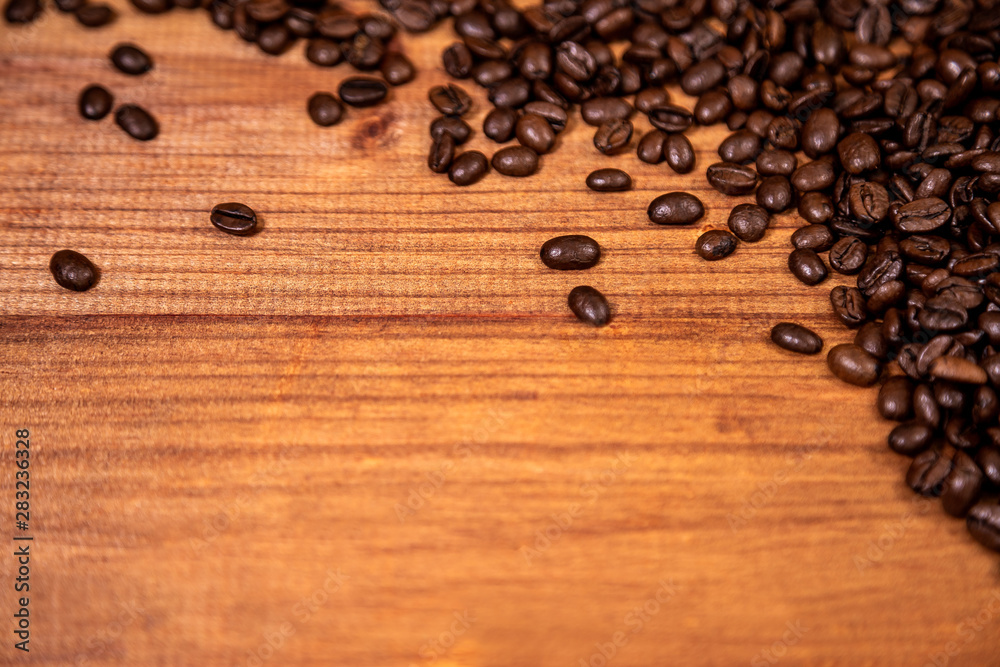 Fototapeta premium A coffee beans over wooden table top background.