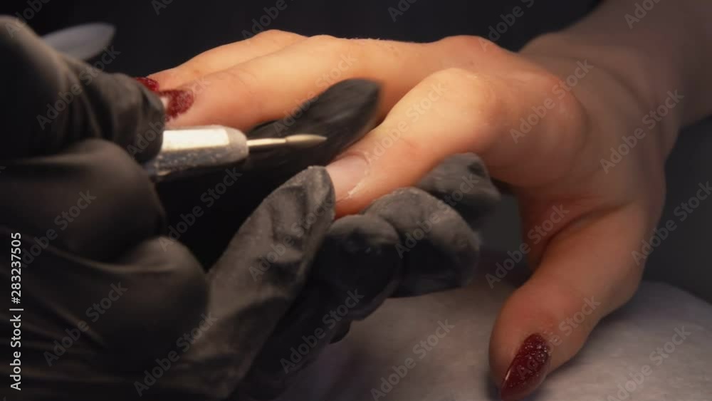 Manicurist does the processing of the cuticle to a special apparatus Manicurist does the processing of the cuticle to a special apparatus