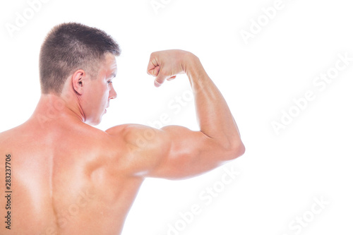 Strong Athletic Man - Fitness Model showing his perfect body isolated on white background with copyspace. Bodybuilder man with perfect abs, shoulders,biceps, triceps and chest.
