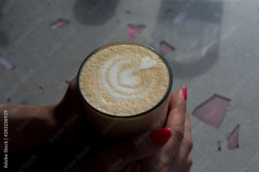 Fototapeta premium Cup of latte at woman hands