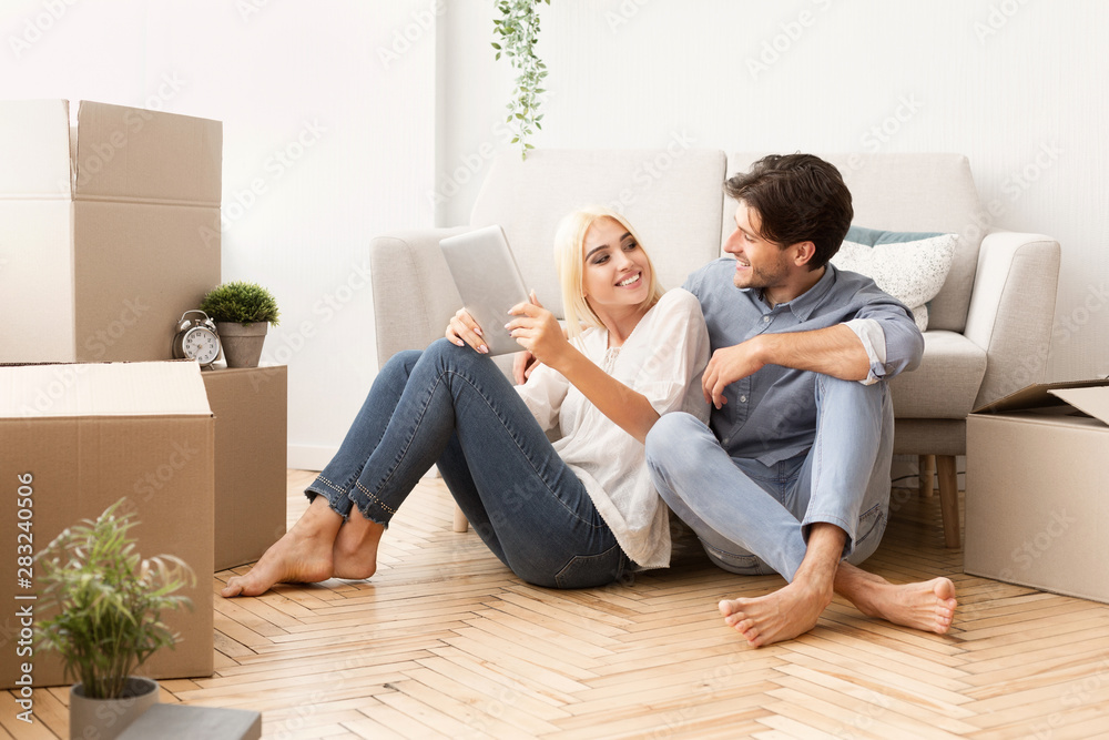 Young Couple Relaxing On Floor Using Digital Tablet Young Couple Relaxing On Floor Using Digital Tablet