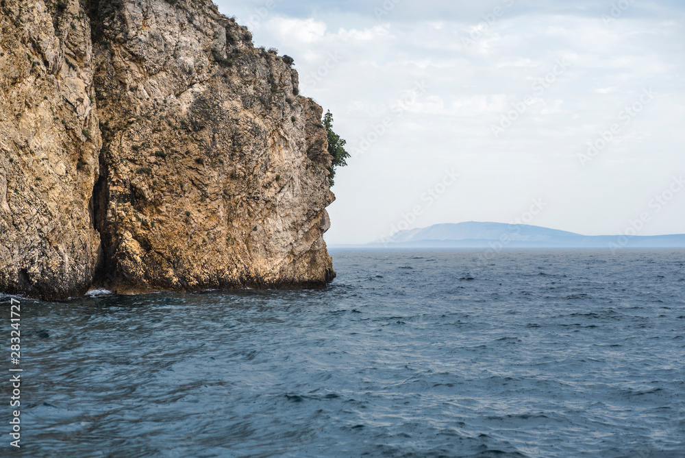 Sea Balkan atmospheric landscape with a rock going into the sea. Adriatic Sea