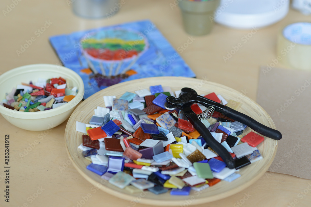 Process of making a mosaic picture from ceramic tile. The man organizes with a tweezers a puzzle of ceramic elements to build a picture. Process of making a mosaic picture from ceramic tile. The man organizes with a tweezers a puzzle of ceramic elements to build a picture.