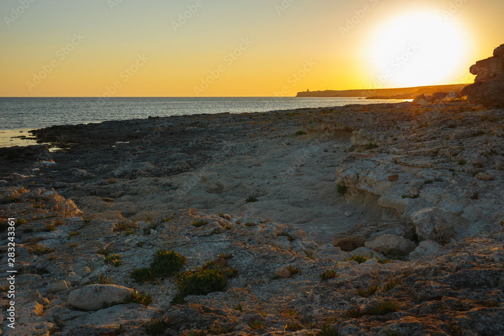 Sunset on a background of sea stone coast