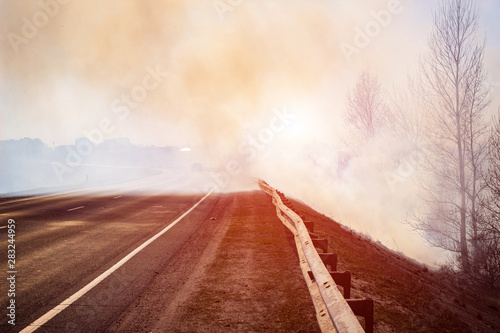 road in the smoke from forest fires on the background of the forest