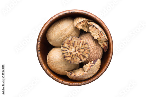 Cuadro en lienzo whole nutmeg spice in wooden bowl, isolated on white background