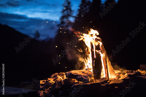 Camping bonfire with yellow and red flames in summer, forest. Copy space. photo