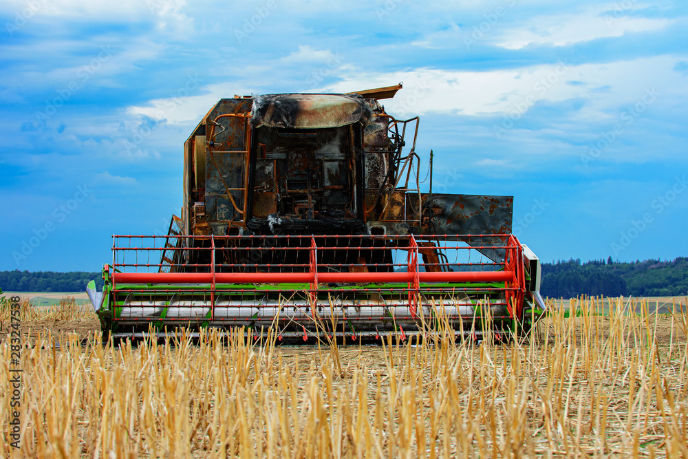 Fototapeta premium Ausgebrannter Mähdrescher auf einem Feld