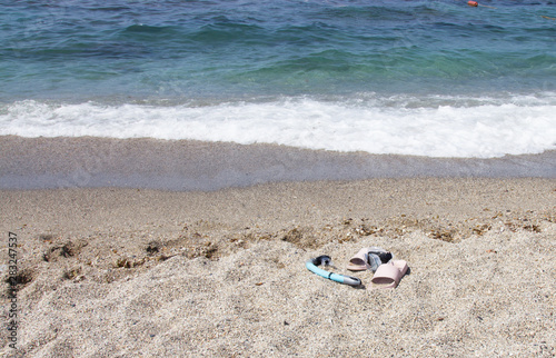 Mask, snorkel and beach Slippers on the sandy beach by the sea. Sea holidays in southern countries