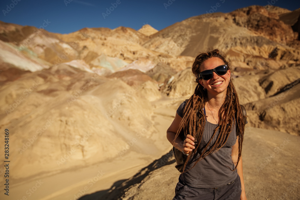 Naklejka premium A hiker in the Artist`s Palette landmark place in Death Valley National Park, Geology, sand.