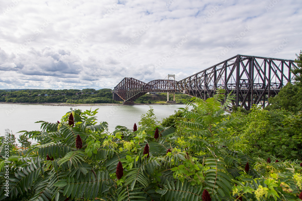 Fototapeta premium Beautiful view of the 1919 steel Quebec Bridge and the 1970 Pierre Laporte bridge over the St. Lawrence river seen from the Ste. Foy sector of the north shore, Quebec City, Quebec, Canada