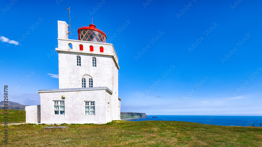 Landscape with white lighthouse at Cape Dyrholaey Landscape with white lighthouse at Cape Dyrholaey